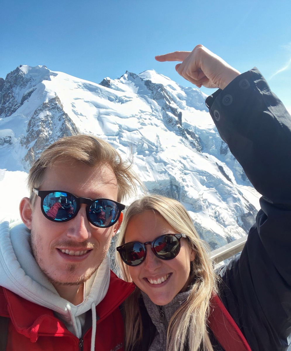 Patricia and Nikolas taking a selfie in front of a snowy Alpine peak