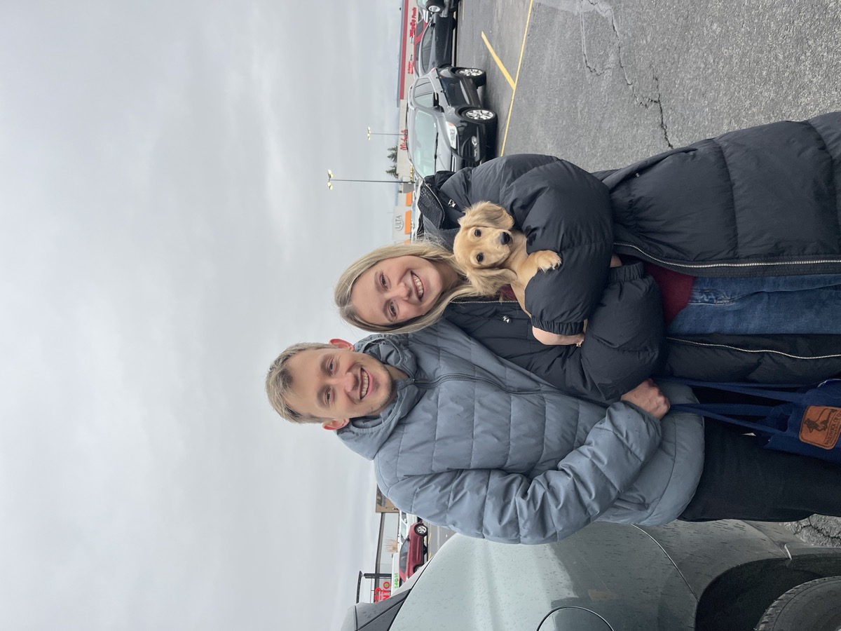 Patricia and Nikolas holding their new dachshund puppy